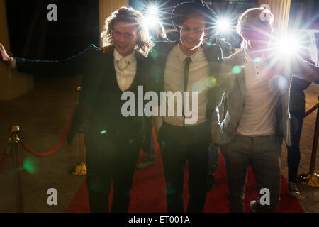 Celebridades llegando y saludando a los fotógrafos paparazzi en evento de alfombra roja