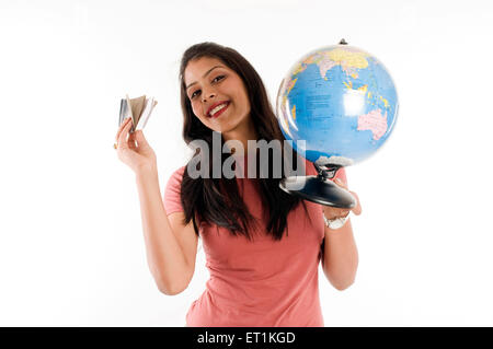 Chica sujetando globe y mostrando el pasaporte en Pune, en Maharashtra, India Asia MR#686Z Foto de stock