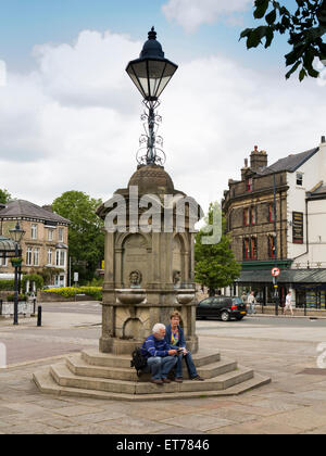 Reino Unido, Inglaterra, Derbyshire, Buxton, la Media Luna, la pareja se sentó sobre Samuel Turner Memorial el fuente de agua potable pasos Foto de stock