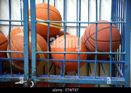 Caucho viejo carrito pelotas en el gimnasio de la escuela como una cárcel Foto de stock