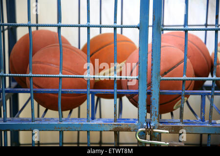 Caucho viejo carrito pelotas en el gimnasio de la escuela como una cárcel Foto de stock