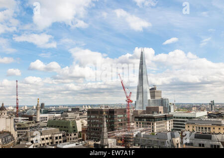 Skyline londinense y paisaje dominado por el Shard, con grúas torre, en un día soleado con el cielo azul y las nubes blancas Foto de stock