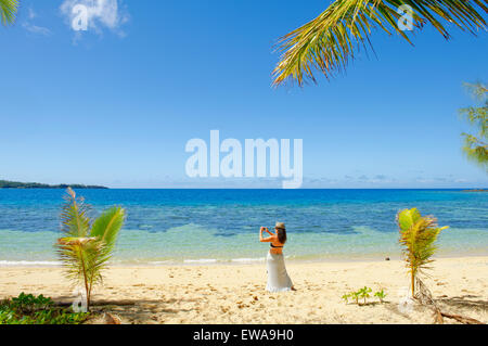 Mujer fotografiando una playa tropical, Drawaqa Island, el grupo de islas Yasawa, Fiji, Islas del Pacífico Sur, Pacífico Foto de stock