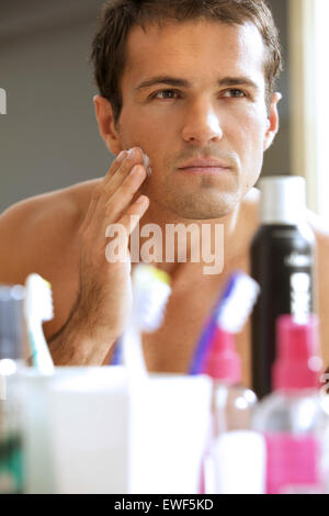 Reflejo de joven en espejo de aplicar la crema de afeitar