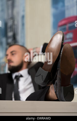 Empresario relajado retrocede con sus pies Foto de stock
