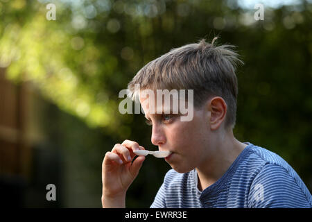 Un niño tomando antihistamínicos medicamentos para ayudar con los síntomas de la fiebre del heno y alergias Foto de stock