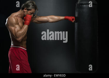 Un hombre con un tatuaje en rojo Guantes boxeo - Boxeo sobre fondo negro:  El concepto de un estilo de vida saludable - La idea para el fi Fotografía  de stock - Alamy