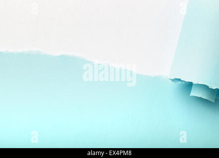 Desgarro en un pedazo de papel azul revelando fondo blanco debajo