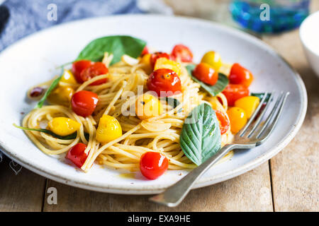 Espaguetis con tomate cherry rojo y amarillo por mar de sal Foto de stock
