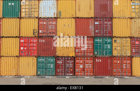 Varias marcas y colores de los contenedores apilados Foto de stock