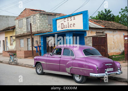 Un vintage Chevrolet púrpura está constreñida por las calles de Trinidad, Cuba