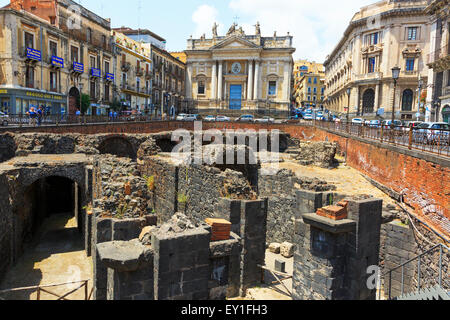 Restos de un anfiteatro romano en el centro de la ciudad de Catania con el ornamentado edificio de San Biago detrás. Sicilia, Italia