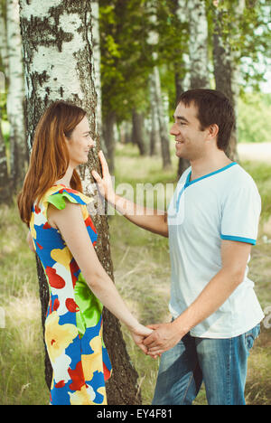Joven feliz pareja tomados de las manos en el parque en el verano. Foto de stock