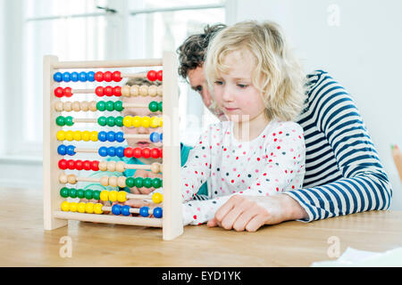 Padre e hijos calculando con abacus Foto de stock