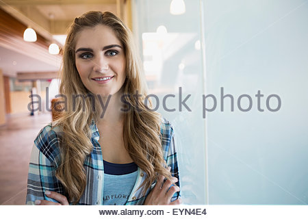 Retrato seguro joven mujer rubia en la ventana