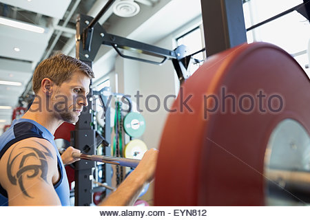 El hombre se preparan para el levantamiento de pesas en el gimnasio barbell en
