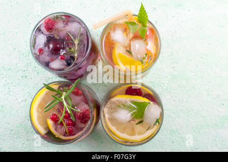 Cuatro cócteles de fruta no alcohólicas colocadas sobre la mesa verde vista desde arriba. Bebidas Frías Foto de stock