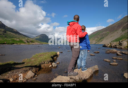 Un padre y su hijo disfrute de la vista en el agua residual en el distrito de los lagos de Cumbria, Reino Unido Foto de stock