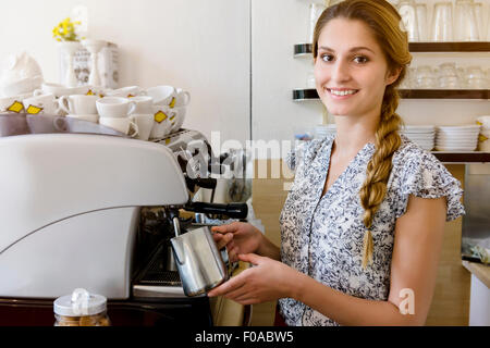 Mujer joven con cafetera mirando a la cámara, Retrato Foto de stock