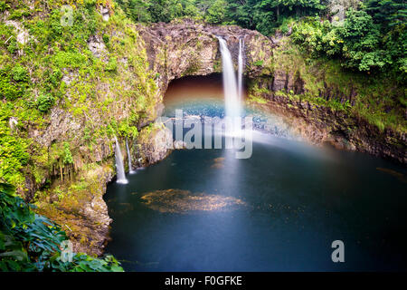 Hermosa Arcoiris cae en Hilo Hawaii formas corrientes en cascada en una piscina natural y a menudo arroja colorido arco iris cuando el sol Foto de stock