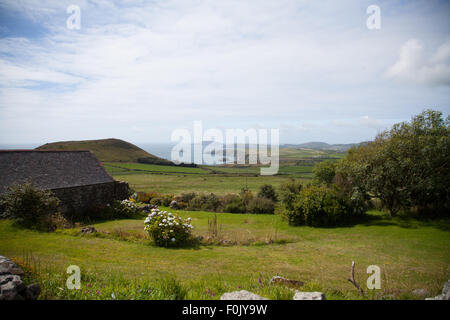 Una vista de Carreg Lefain Rhiw, a través de campos a Penarfynydd con el mar y Ynys Enlli en la distancia en un día de verano