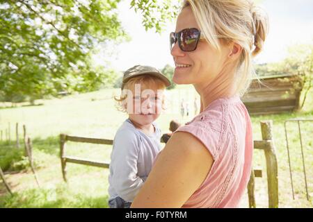 Retrato de mujer madura llevando un hijo pequeño en el campo