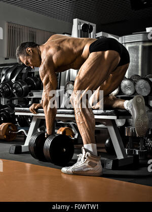 Muy power athletic guy , ejecutar el ejercicio con pesas, sobre fondo bkack Foto de stock