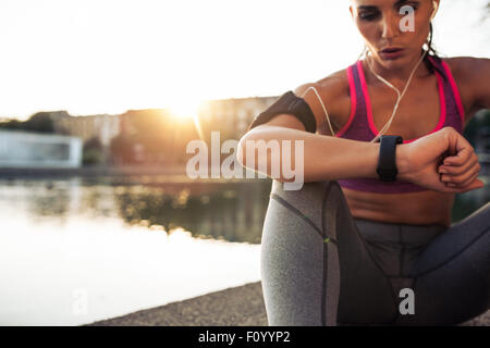 Young beautiful slim fit woman in activewear resting at yoga class