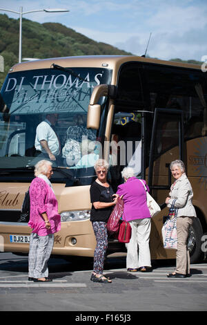 Cuatro mujeres mayores turistas subir a un autobús autobús va para un viaje de un día de excursión, viaje UK Foto de stock