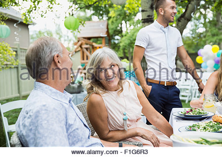 Senior sonriente pareja disfrutando garden party almuerzo