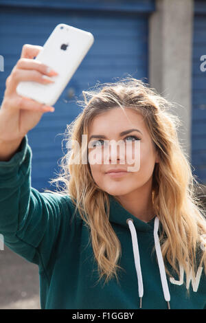 Bastante adolescente teniendo un selfie de ella fuera en la calle. Foto de stock
