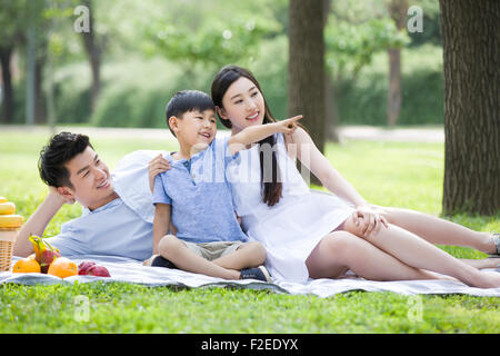 Feliz familia joven tener un picnic en la hierba