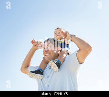 Ángulo de visión baja de Hispanic padre hijo llevando a hombros Foto de stock