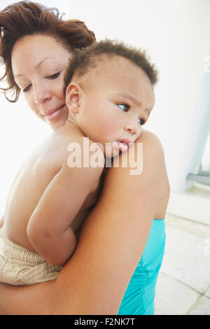 Cerca de la madre negra reconfortante hijo
