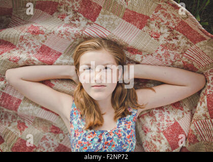 Chica caucásica sentar sobre una manta