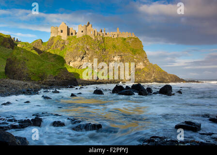 Amanecer sobre Castillo de Dunluce a lo largo de la costa norte del Condado de Antrim, Irlanda del Norte, REINO UNIDO Foto de stock