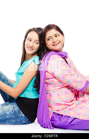 2 madre india y joven hija sentados espalda con espalda Foto de stock