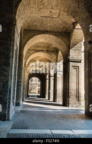 Arco, columnas, el patio y los adoquines en el Palacio de La Pilotta, Parma - Italia
