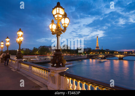 Pont Alexandre III, mirando hacia la Torre Eiffel sobre el Río Sena al anochecer, París, Francia