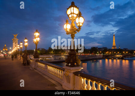 Pont Alexandre III, mirando hacia la Torre Eiffel sobre el Río Sena al anochecer, París, Francia