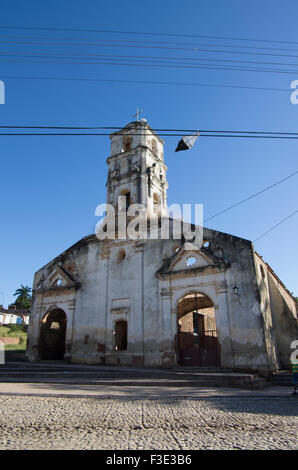 Una cometa cuelga de un cable de teléfono delante de una antigua iglesia en Trinidad, provincia de Sancti Spiritus en la República de Cuba Foto de stock