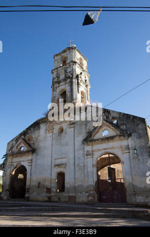 Una cometa cuelga de un cable de teléfono delante de una antigua iglesia en Trinidad, provincia de Sancti Spiritus en la República de Cuba Foto de stock