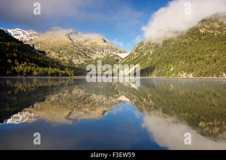 Niebla de la mañana shrowds los picos alrededor de un Lac d'oredon aún en los pirineos. Foto de stock