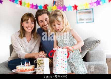 Feliz cumpleaños niña pequeña con caja de regalo en hermoso jardín. Niño  comer feliz cumpleaños rosa cupcake. Colorido pastel decoración al aire  libre. 4 años k Fotografía de stock - Alamy