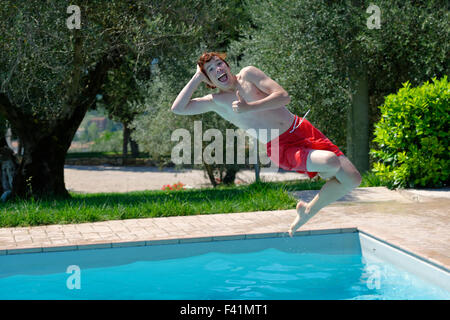Adolescente saltando en una piscina, feliz Foto de stock