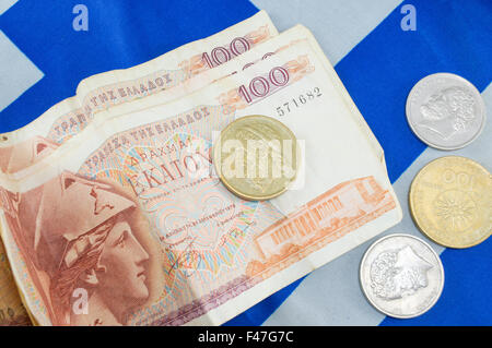 Moneda antigua griego dracma billetes apilados en la bandera griega Foto de stock