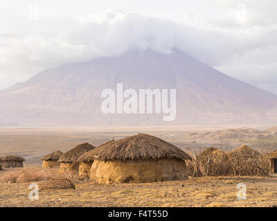 Aldea masai en frente del ol Doinyo Lengai (Montaña de Dios en la lengua de los Maasai) en Tanzania, África. Foto de stock