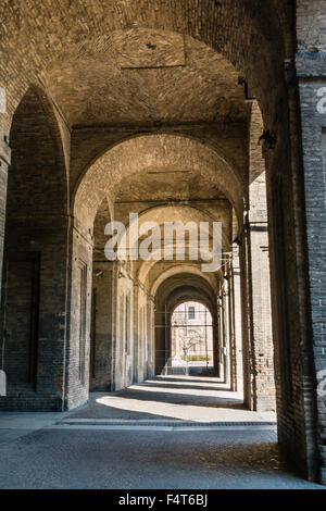 Arco, columnas, el patio y los adoquines en el Palacio de La Pilotta, Parma - Italia