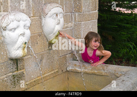 Cinco años de edad, niña jugando en una fuente de agua en San Agustín, Florida, EE.UU. Foto de stock