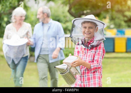 Retrato de niño en el apicultor sombrero sonriente Celebración fumador Foto de stock